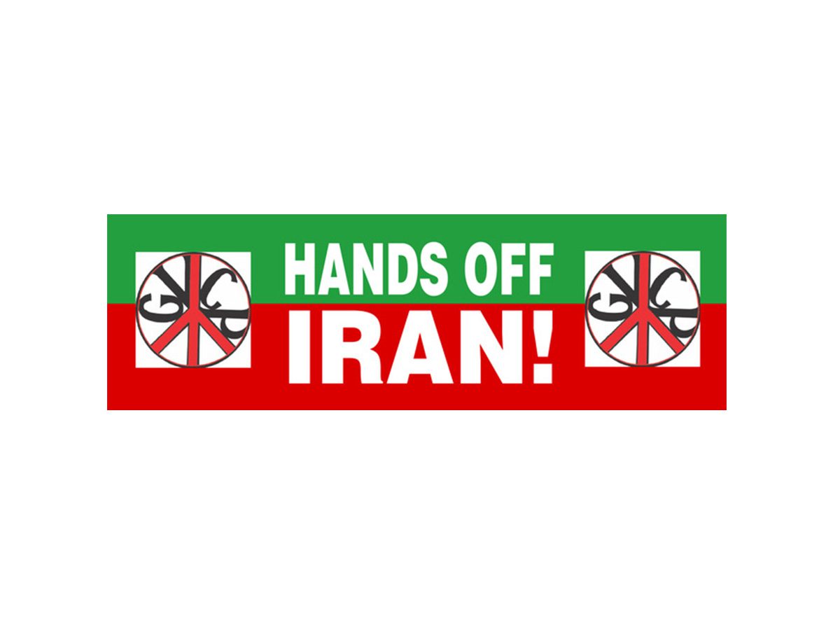 A protest sign with the words "HANDS OFF IRAN!" in bold white letters on a red and green background, flanked by peace symbols on each side.