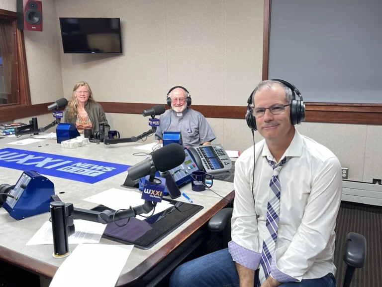 Radio station hosts discussing in studio.
