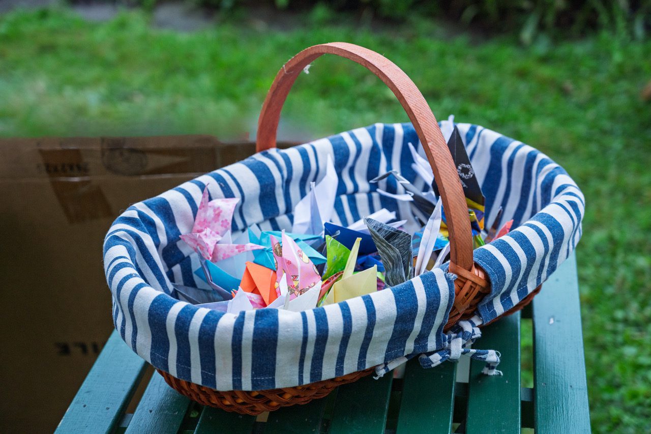 Wicker basket filled with colorful origami cranes made for the Hiroshima/Nagasaki vigil.